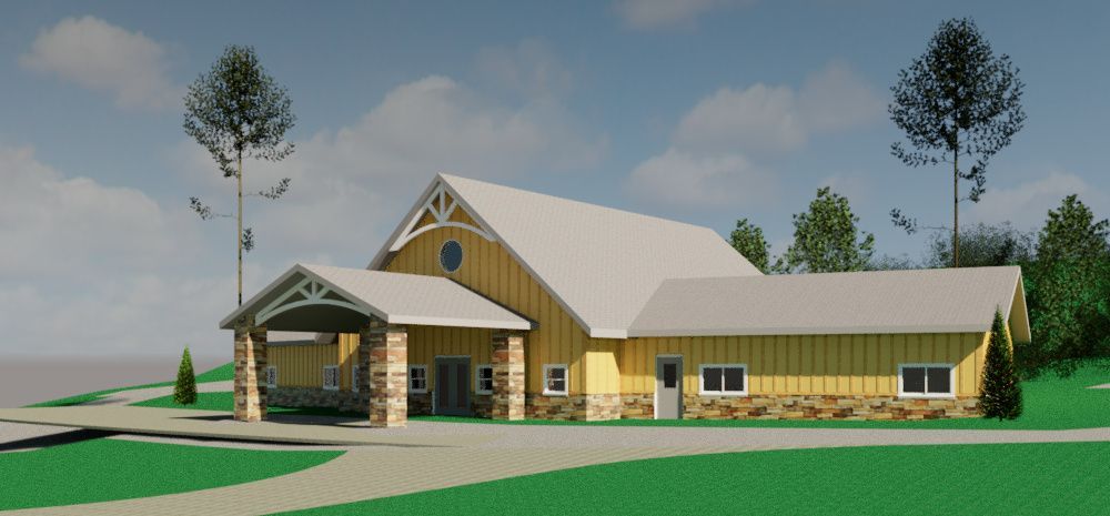 Modern yellow barn-style building with white roof and stone base in a grassy landscape