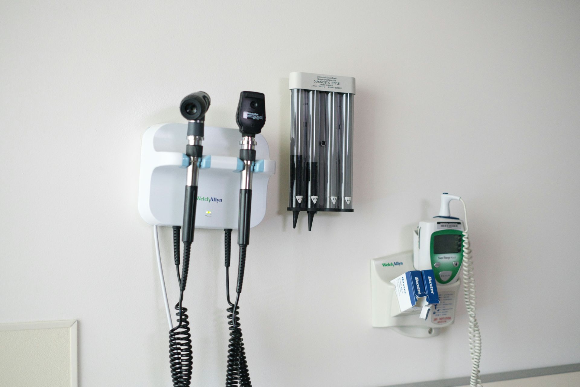 Wall-mounted medical exam tools and blood pressure cuff in a clinic room