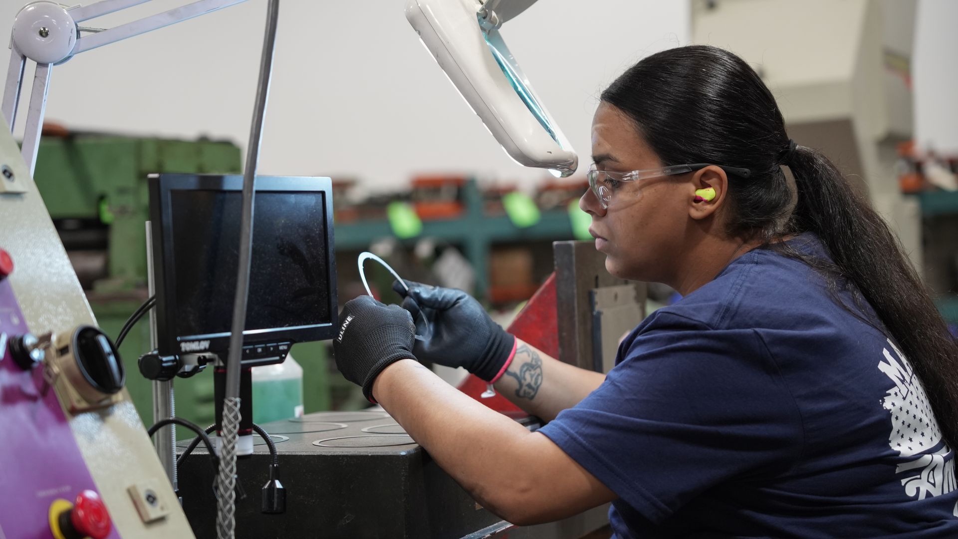 A woman is working on a machine in a factory.