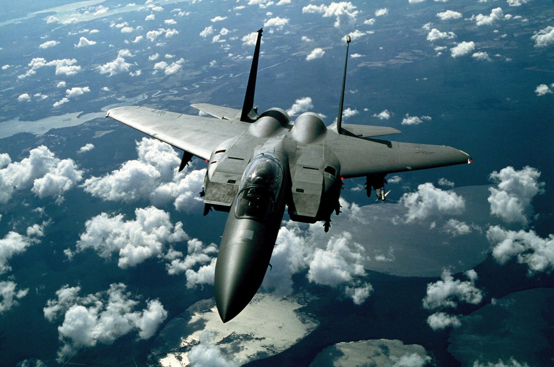 A fighter jet is flying through a cloudy sky