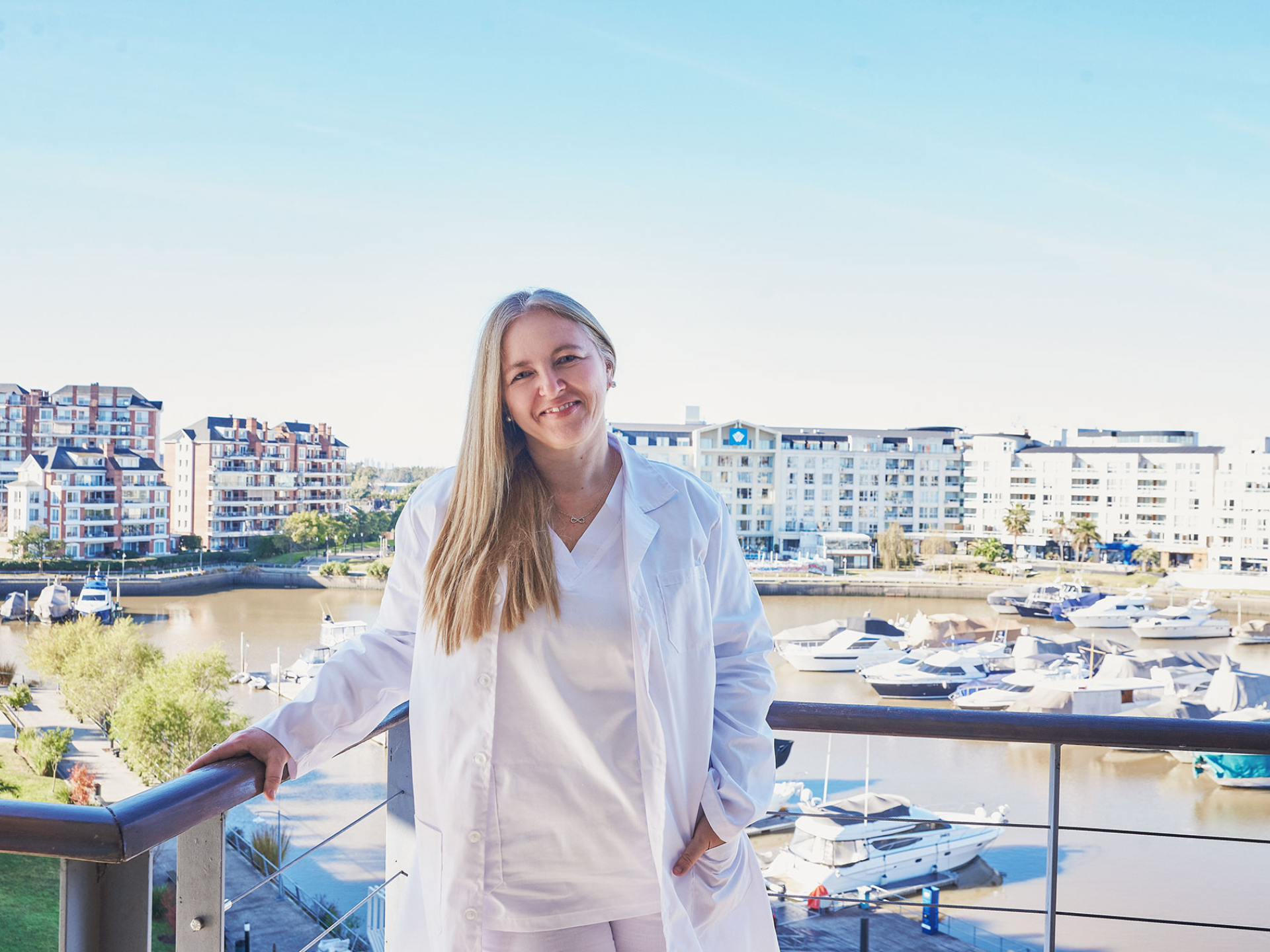 Doctora especialista en salud capilar con bata blanca frente al muelle de Nordelta