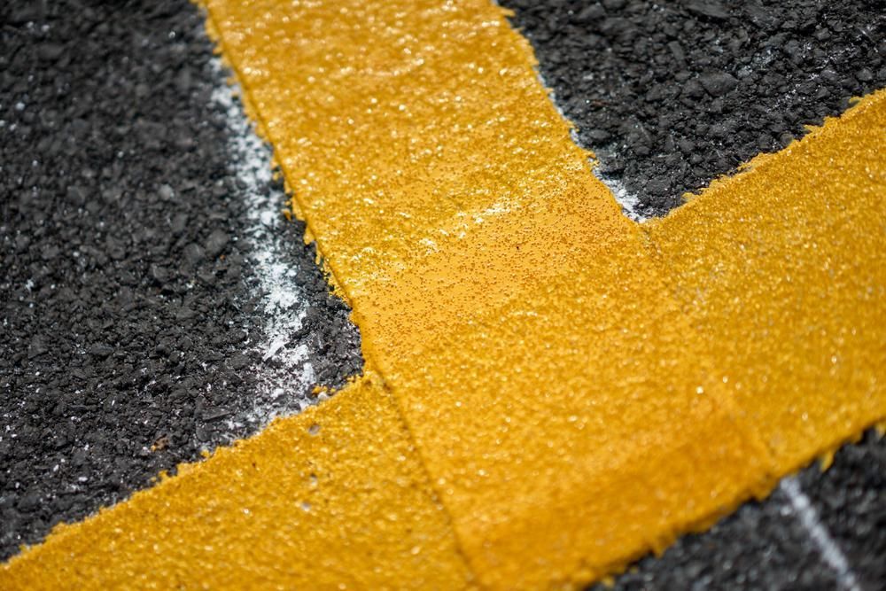 A Close Up of a Yellow Line on a Black Road — North Coast Line Marking in Gold Coast, NSW
