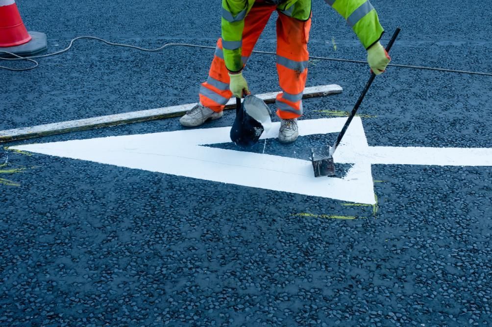 A Man is Painting an Arrow on the Road — North Coast Line Marking in Brisbane, NSW