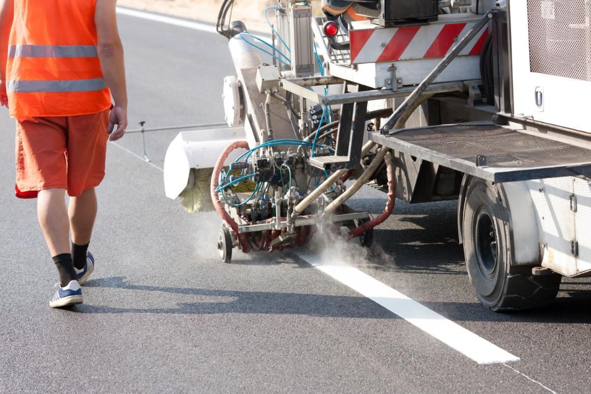 A Man is Walking Past a Machine That is Painting a Line on the Road — North Coast Line Marking in Talofa, NSW