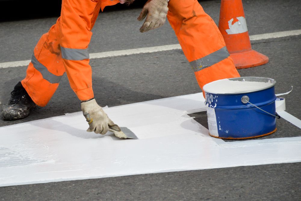 A Man in Orange Pants is Painting a White Line on the Road — North Coast Line Marking in Gold Coast, NSW
