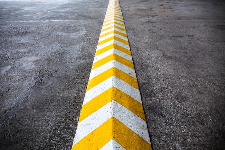 A Yellow and White Arrow Painted on the Side of a Parking Lot — North Coast Line Marking in Brisbane, NSW