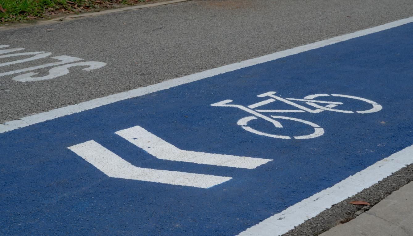 A Blue Bike Lane With White Arrows Painted on It — North Coast Line Marking in Brisbane, NSW