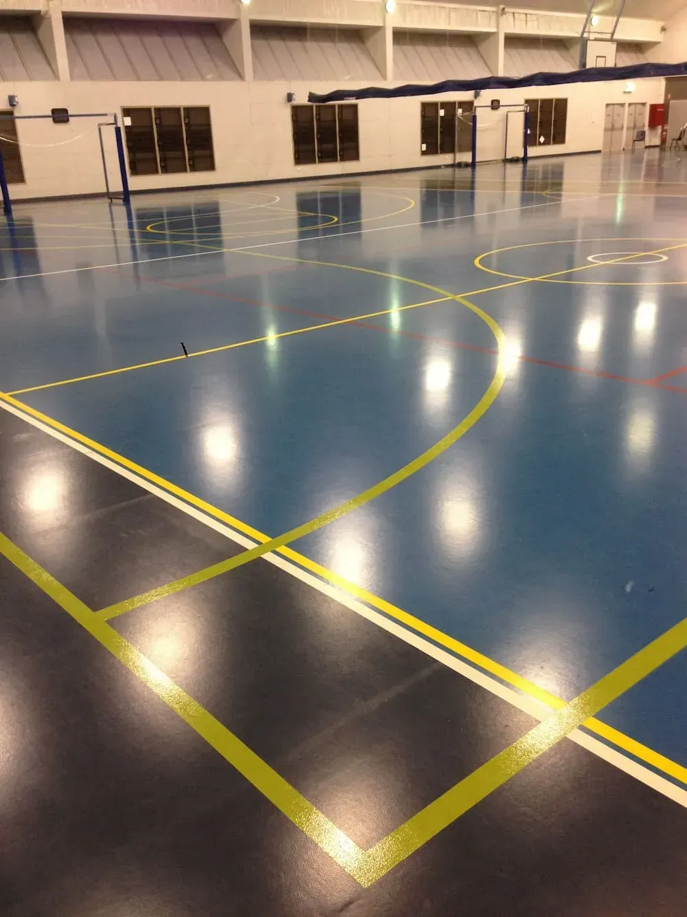 A Basketball Court With a Blue Floor and Yellow Lines — North Coast Line Marking in Byron Bay, NSW
