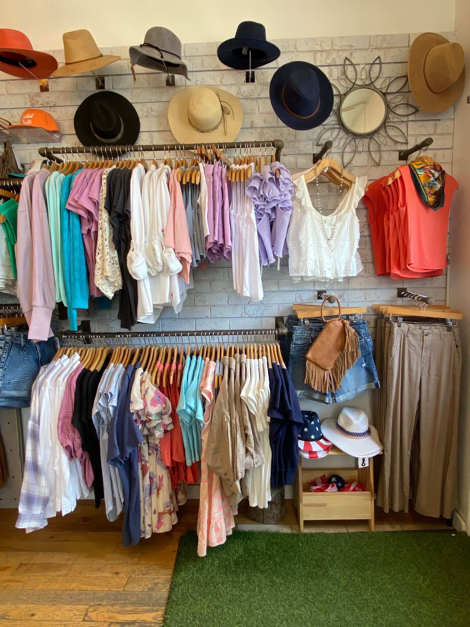 A bunch of swimsuits are hanging on a rack in a store.