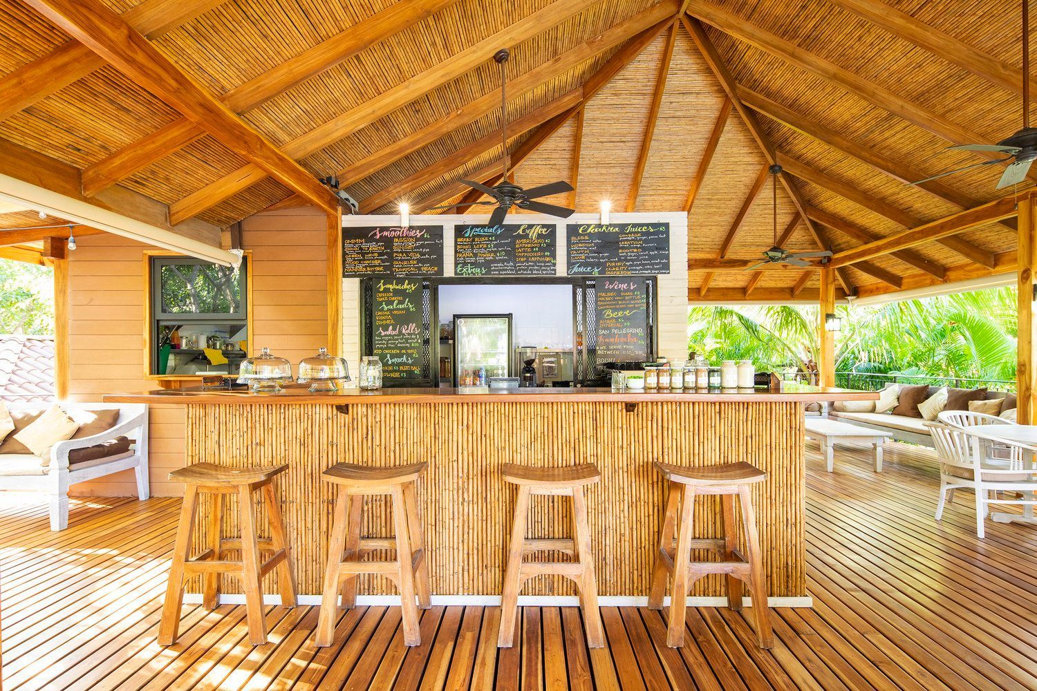 A wooden bar with stools and a thatched roof