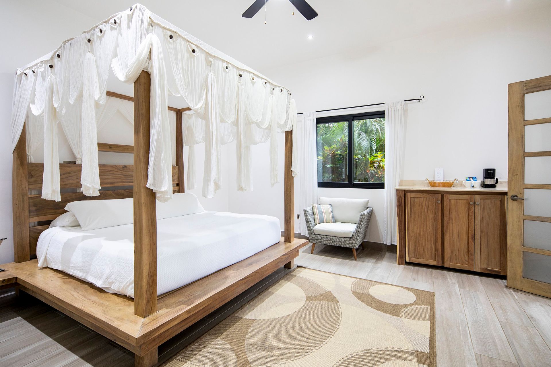 A bedroom with a canopy bed and a ceiling fan.