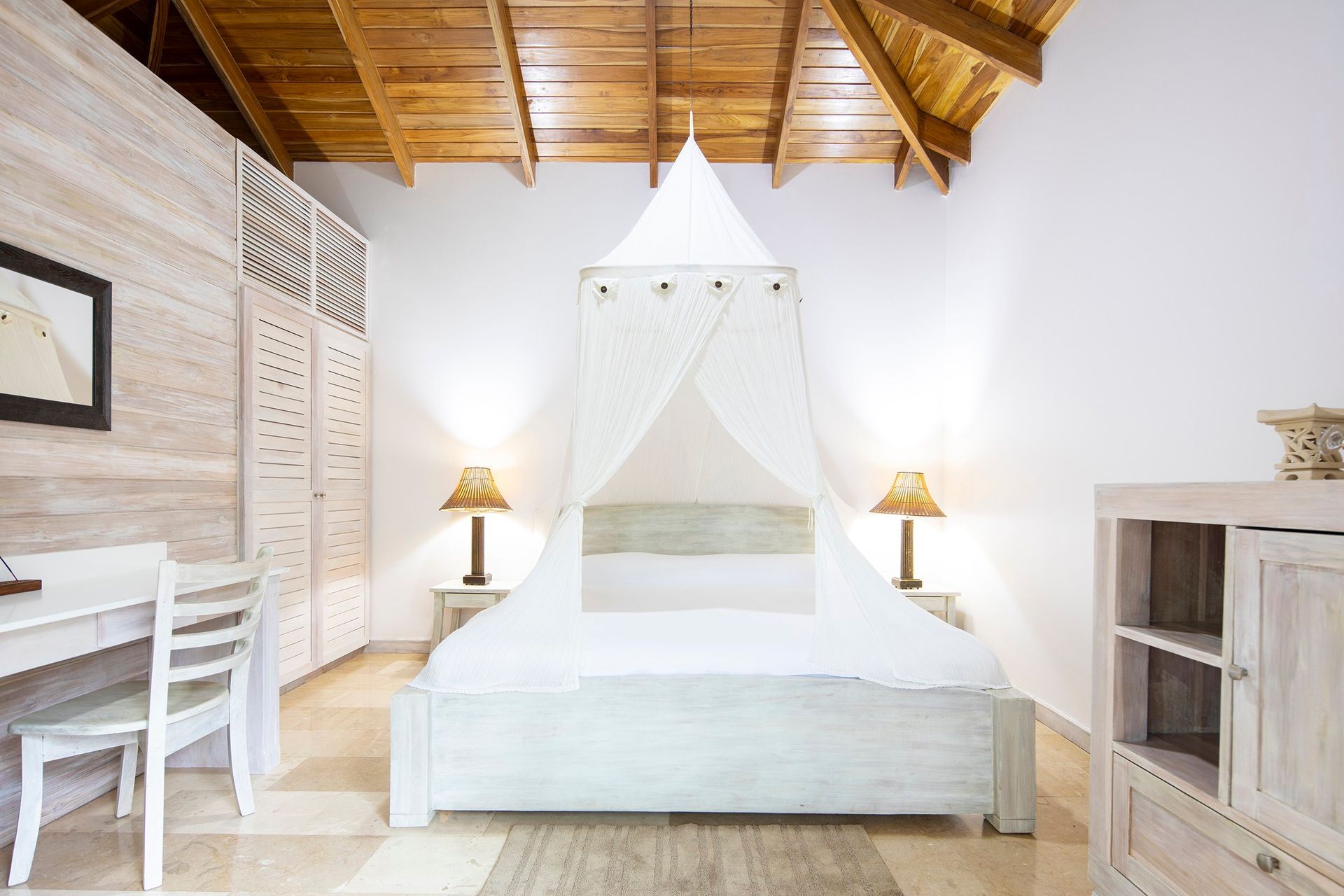 A bedroom with a canopy bed and a desk