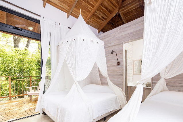 A bedroom with two beds and a canopy bed.