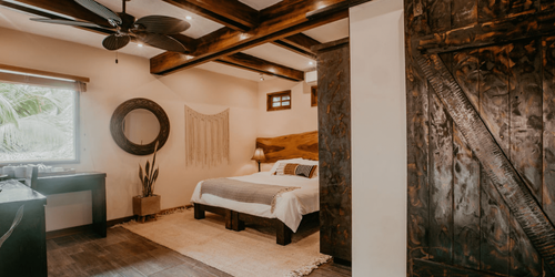 A bedroom with a bed , ceiling fan , and sliding barn door.