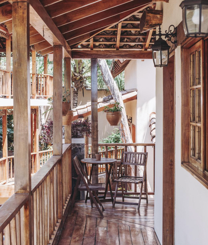 A wooden balcony with a table and chairs on it