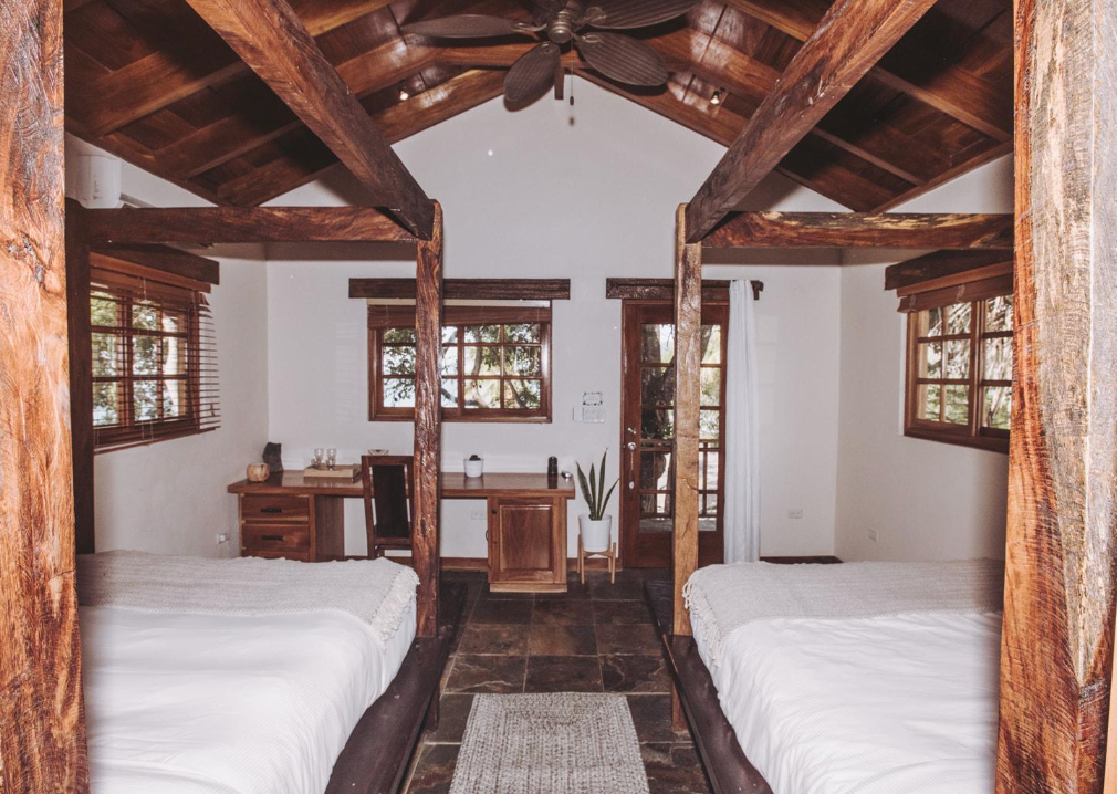 A room with four beds and a ceiling fan.