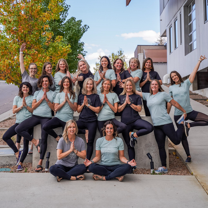 A group of women are posing for a picture in front of a building.