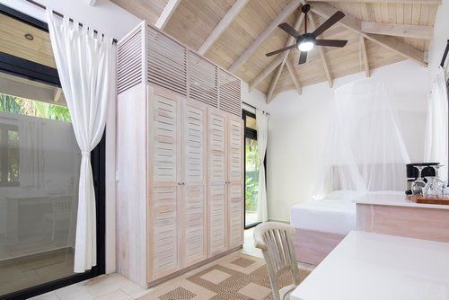 A bedroom with a ceiling fan and a bed.