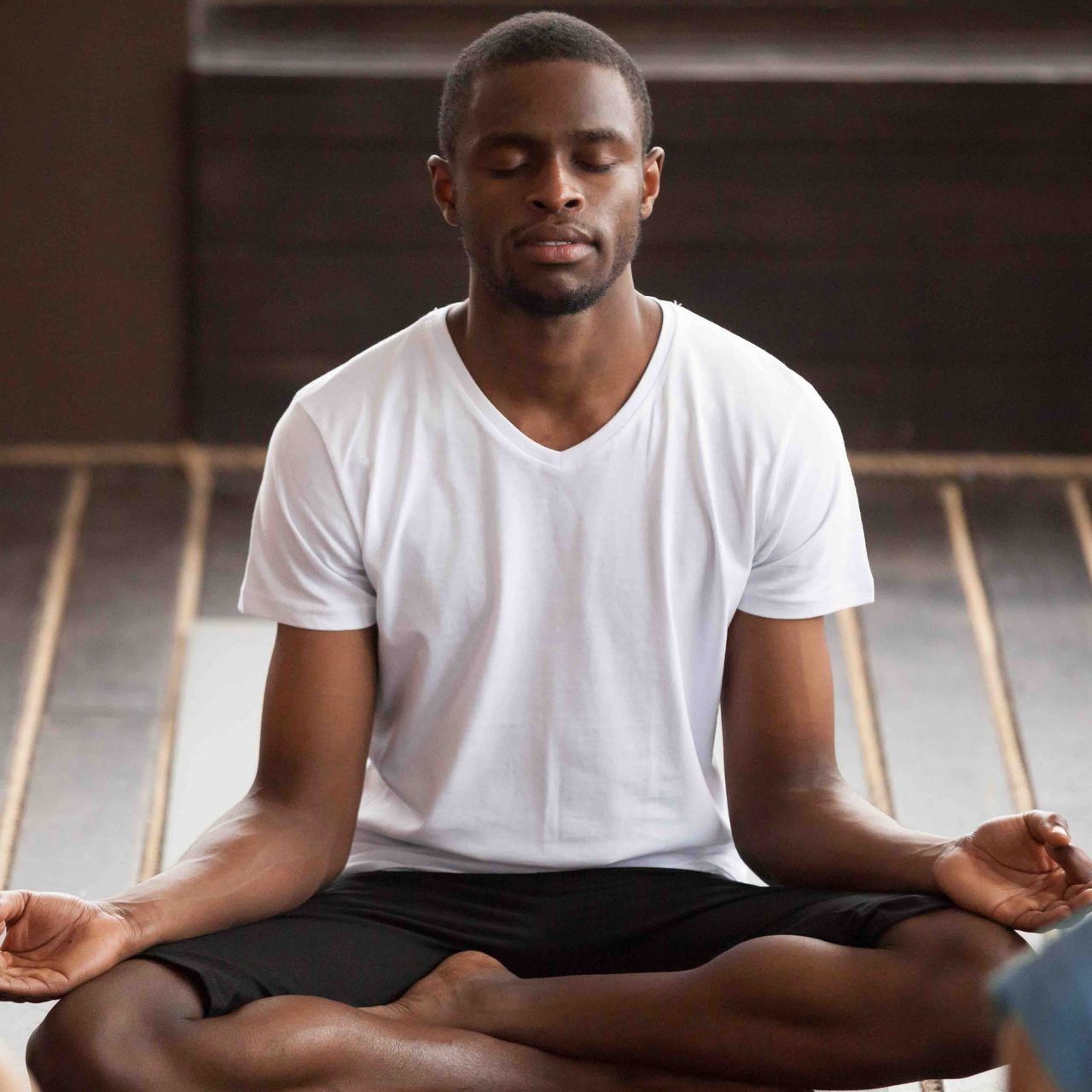A man is sitting in a lotus position with his eyes closed