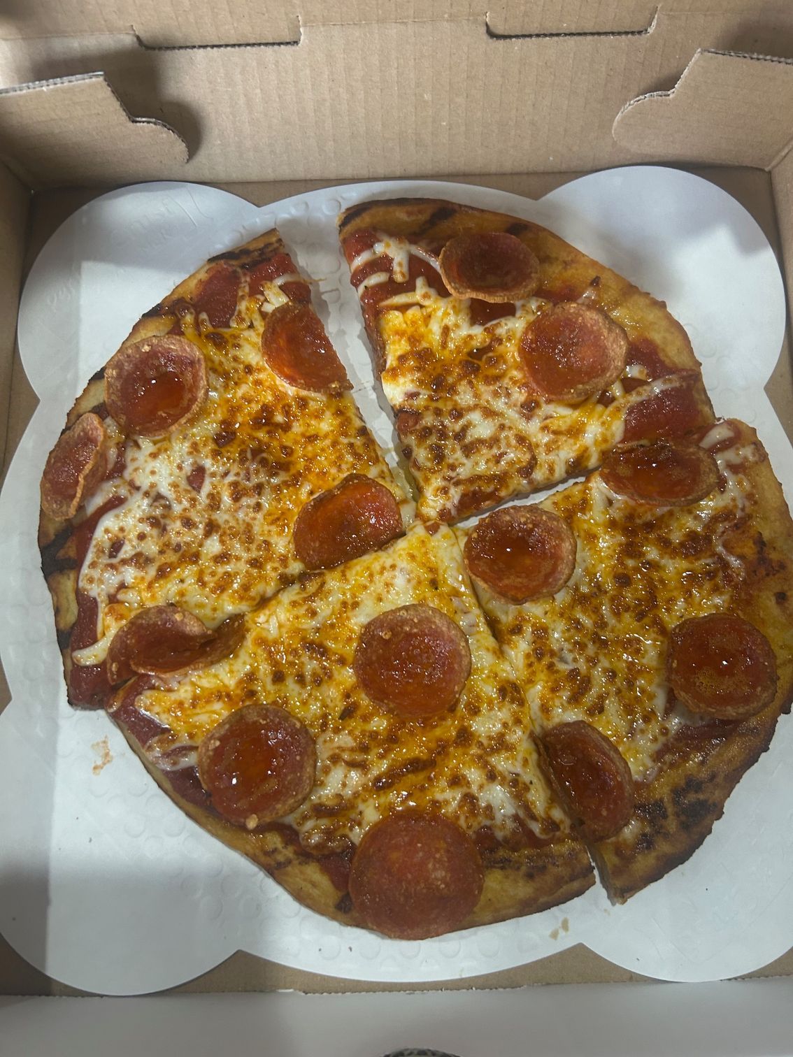 A pepperoni pizza in a box with a slice missing.
