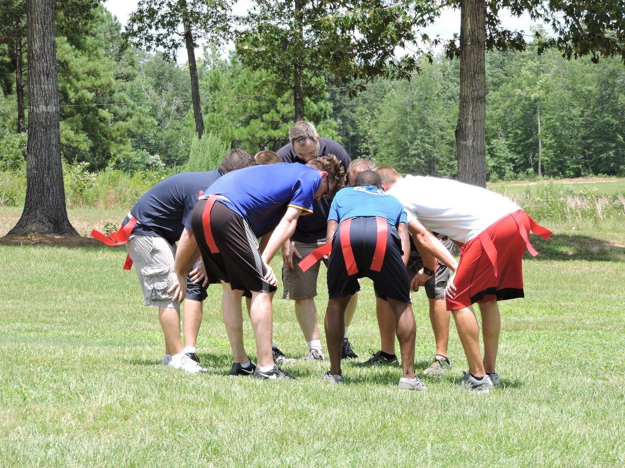 A group of people are huddled together in a field