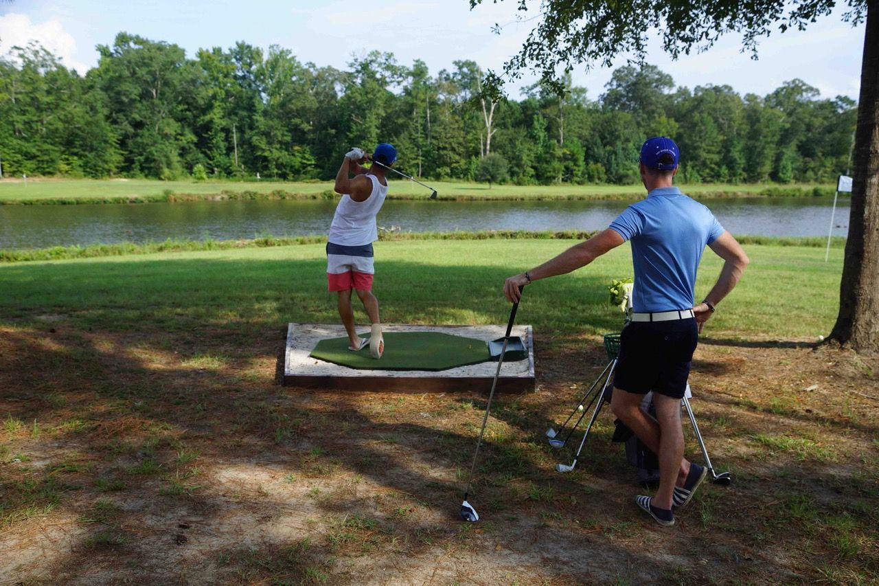 A man and a woman are playing golf on a golf course.