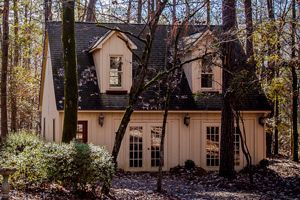 A small house in the middle of a forest surrounded by trees.