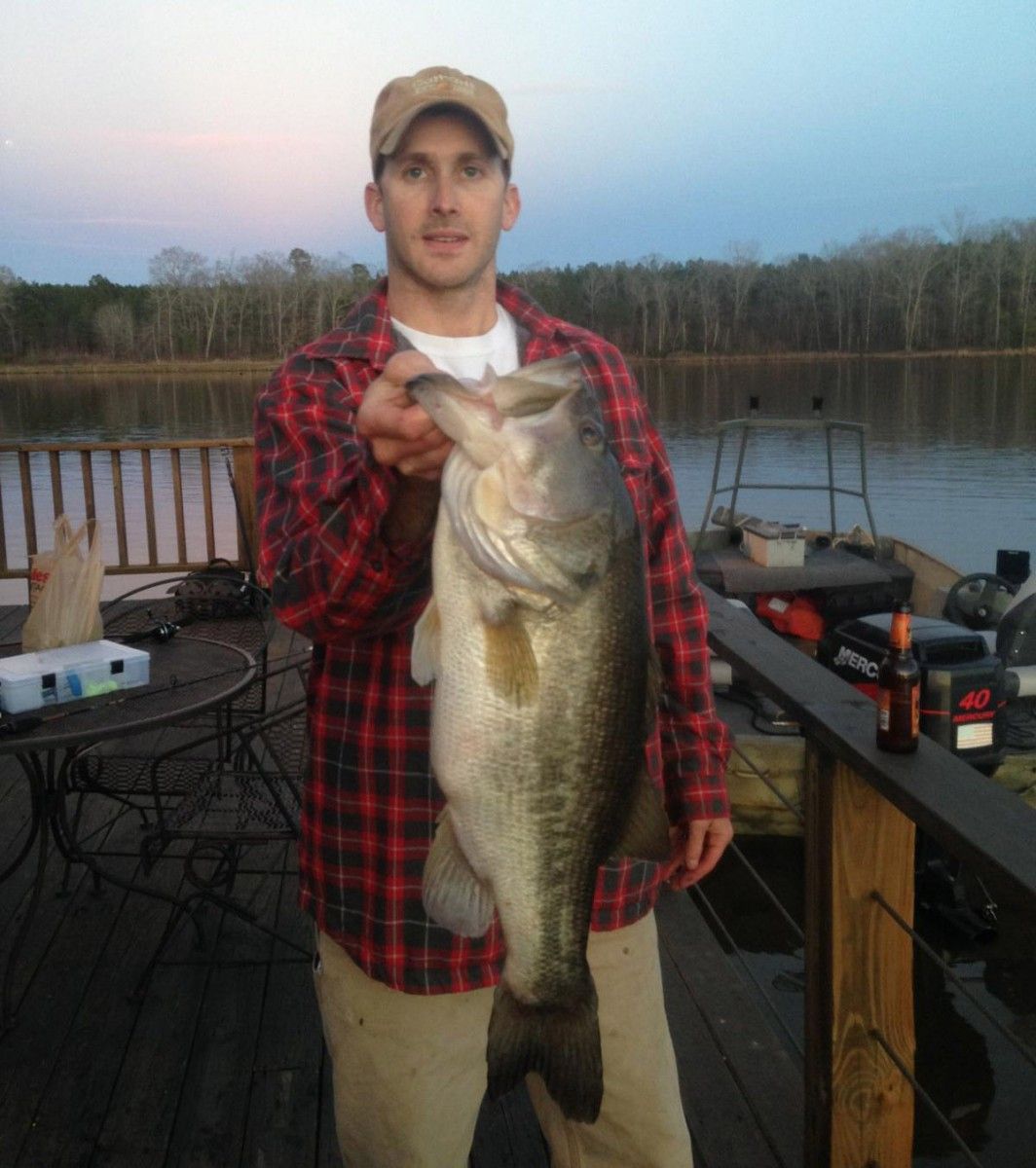 A man in a plaid shirt is holding a large fish