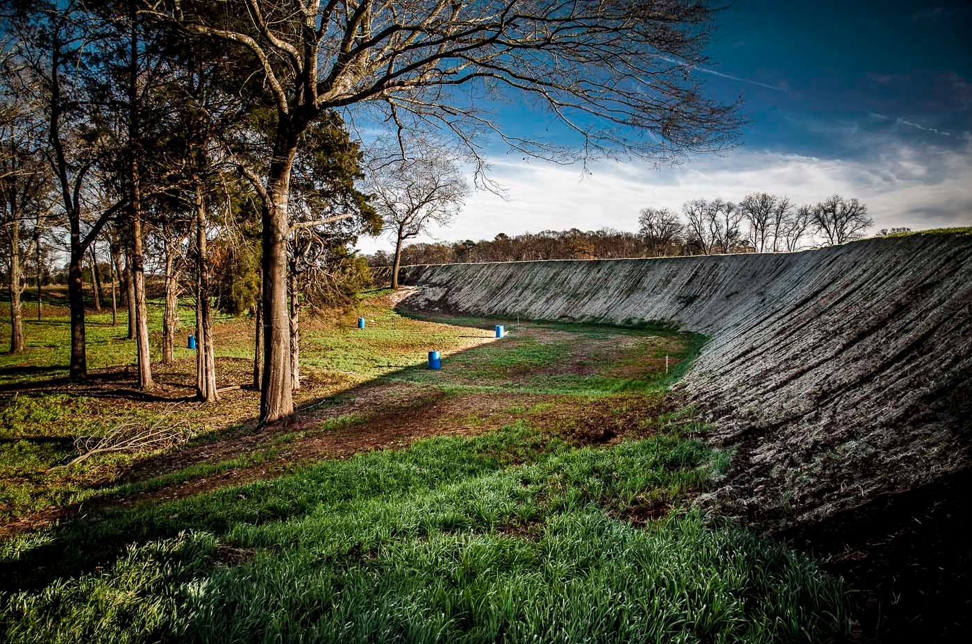 A large body of water surrounded by trees and grass.