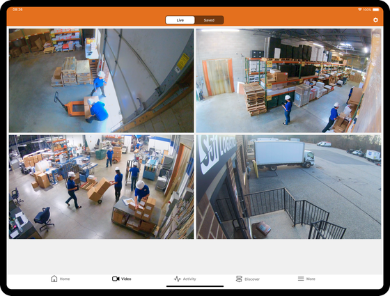 A security camera dashboard showing four views of a warehouse interior and loading dock with workers moving boxes.