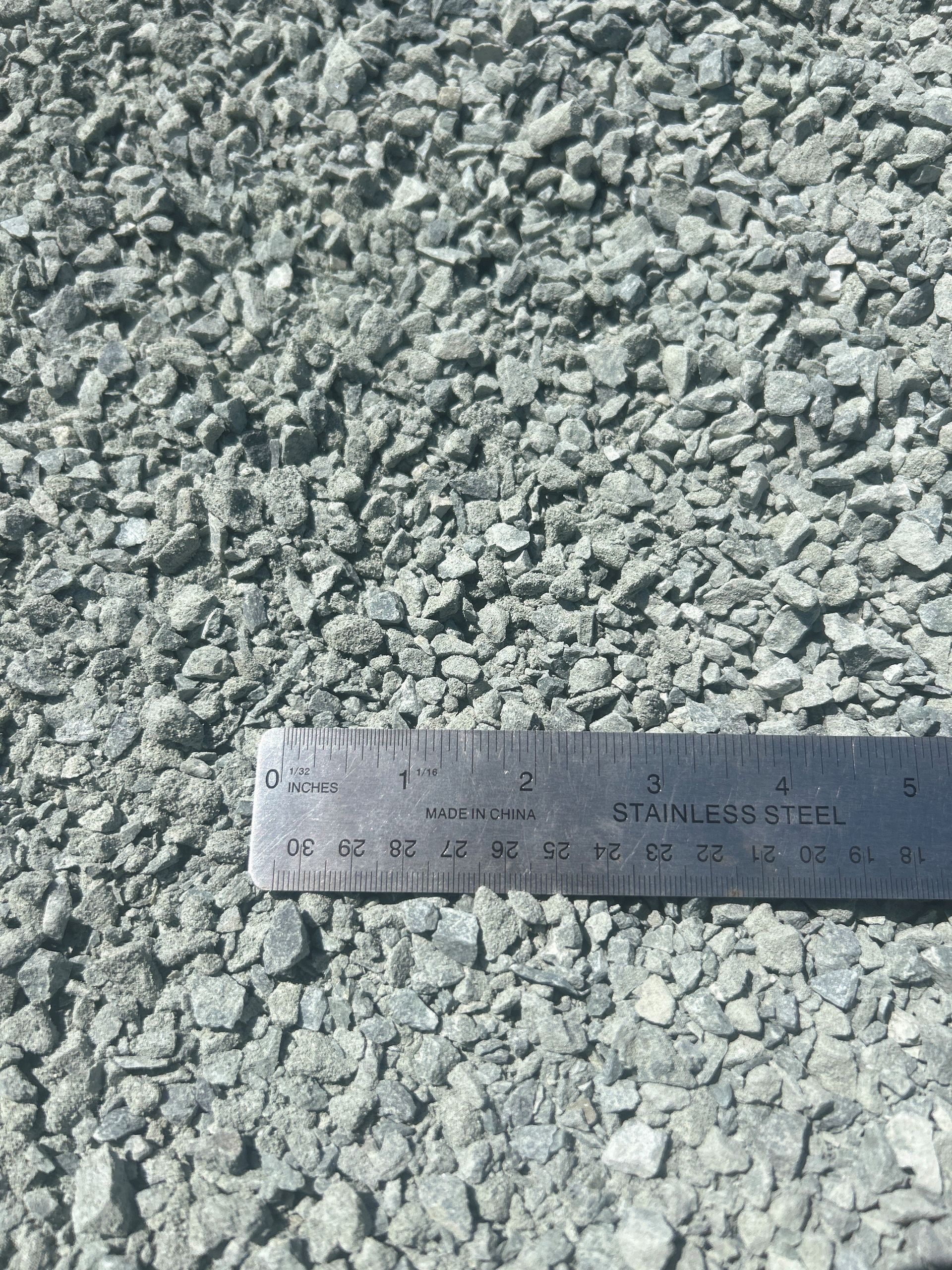 Gray gravel with a stainless steel ruler for scale.