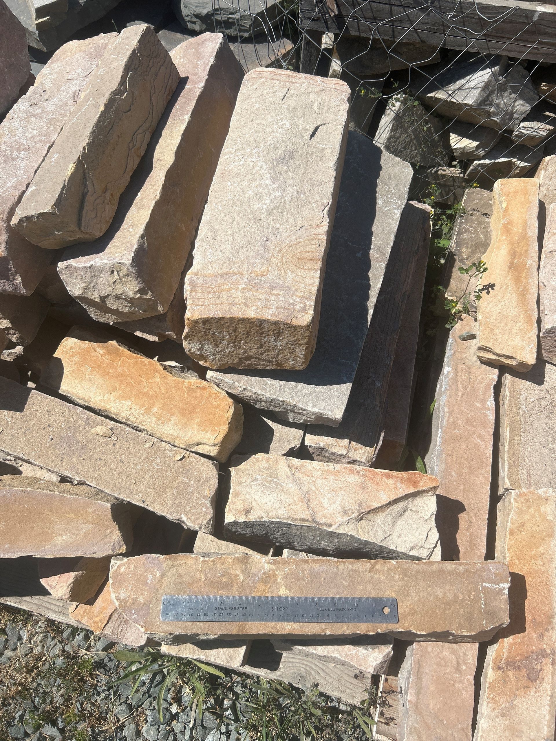 Pile of rectangular tan and gray stones, likely for construction.