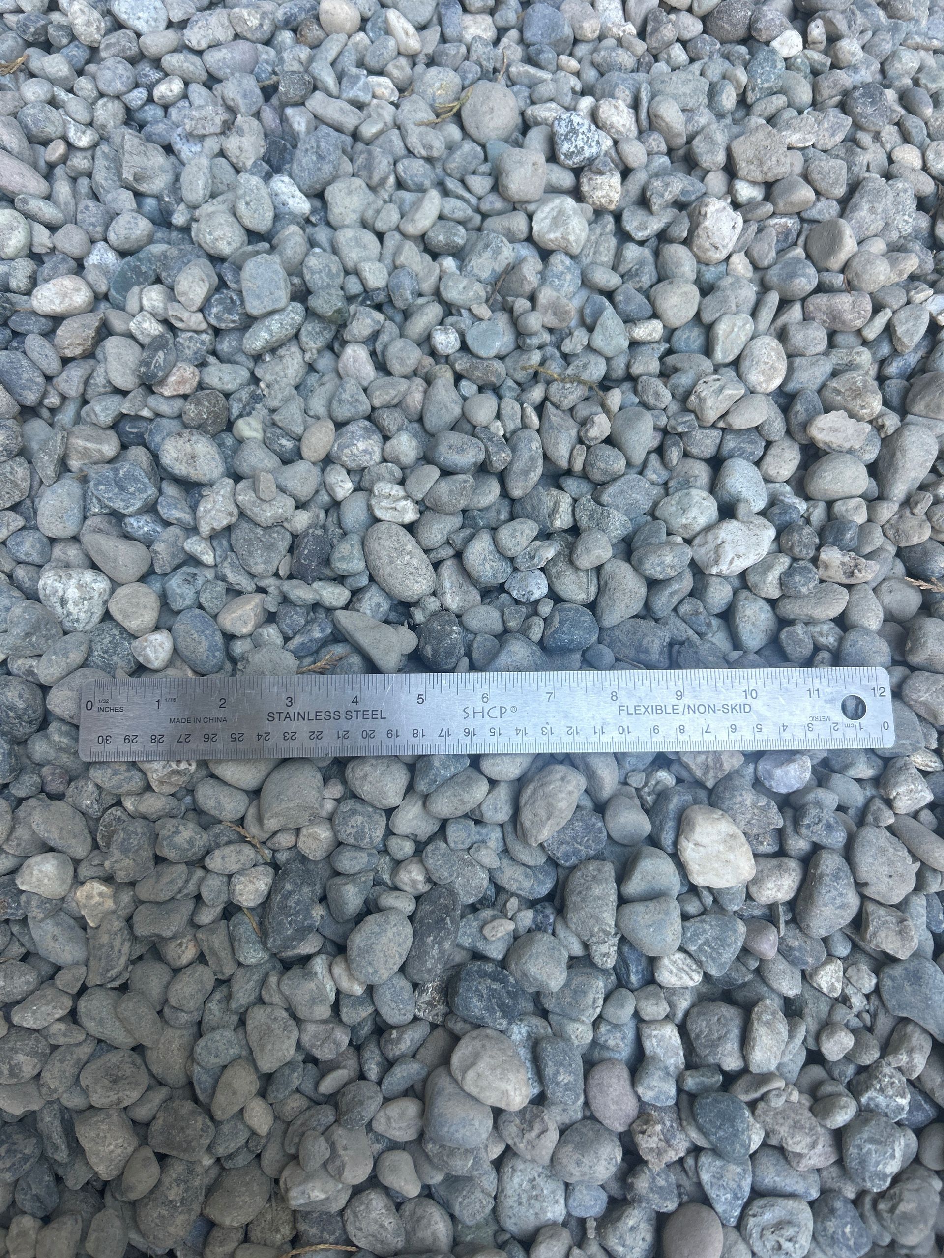 Gray gravel with a ruler laid on top for scale.
