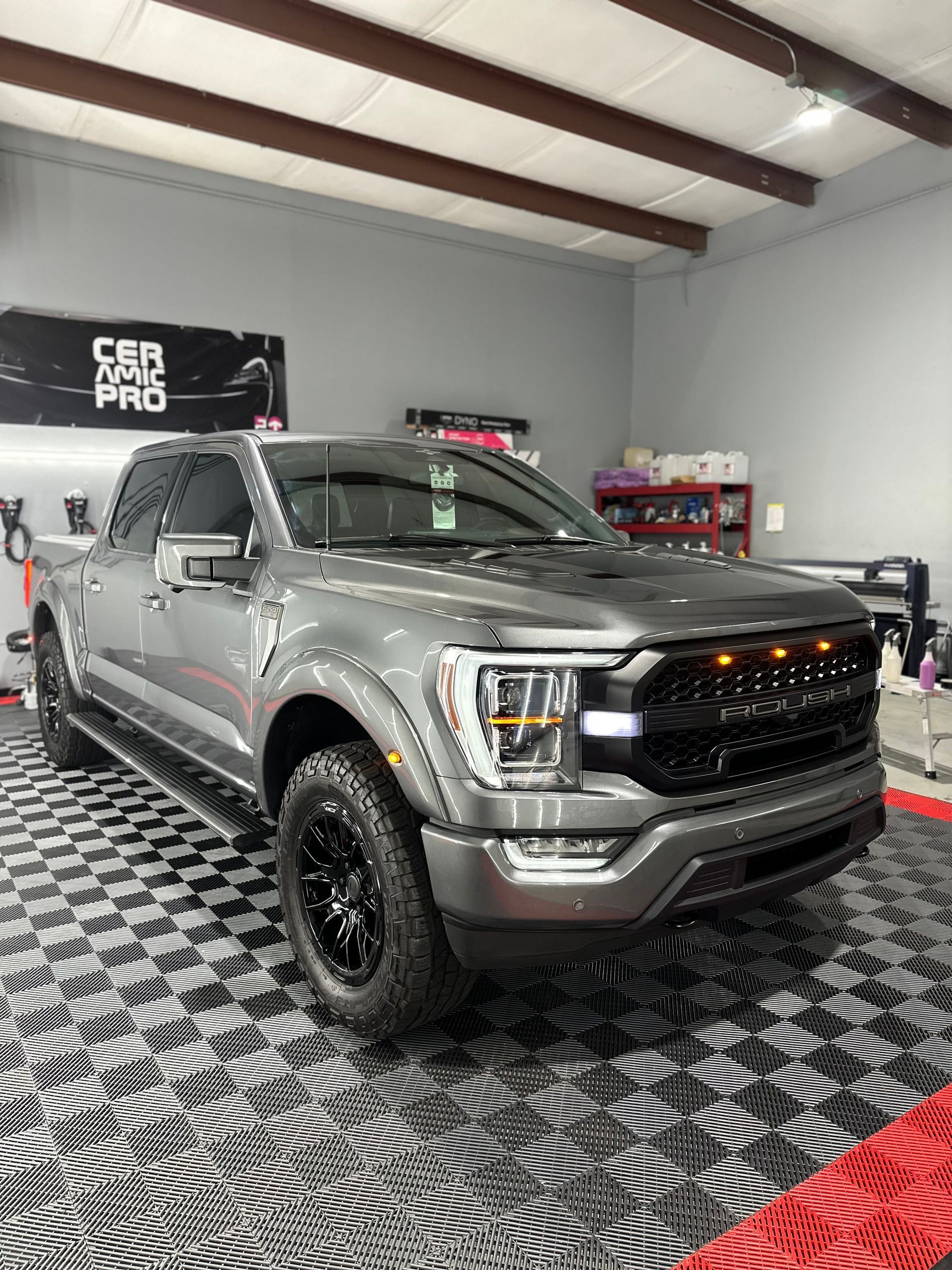 A gray ford f150 is parked in a garage.