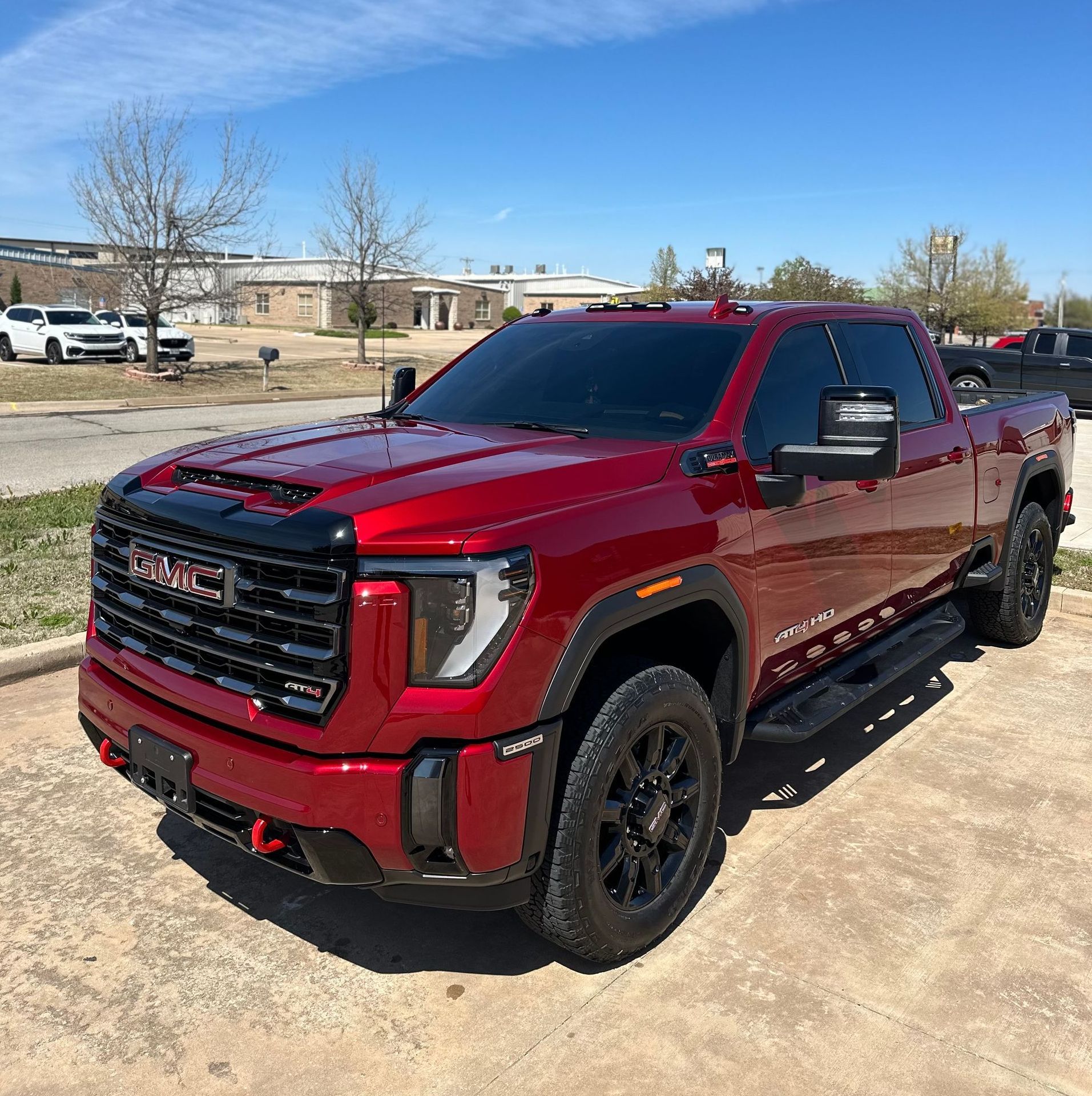 A red gmc truck is parked on the side of the road.