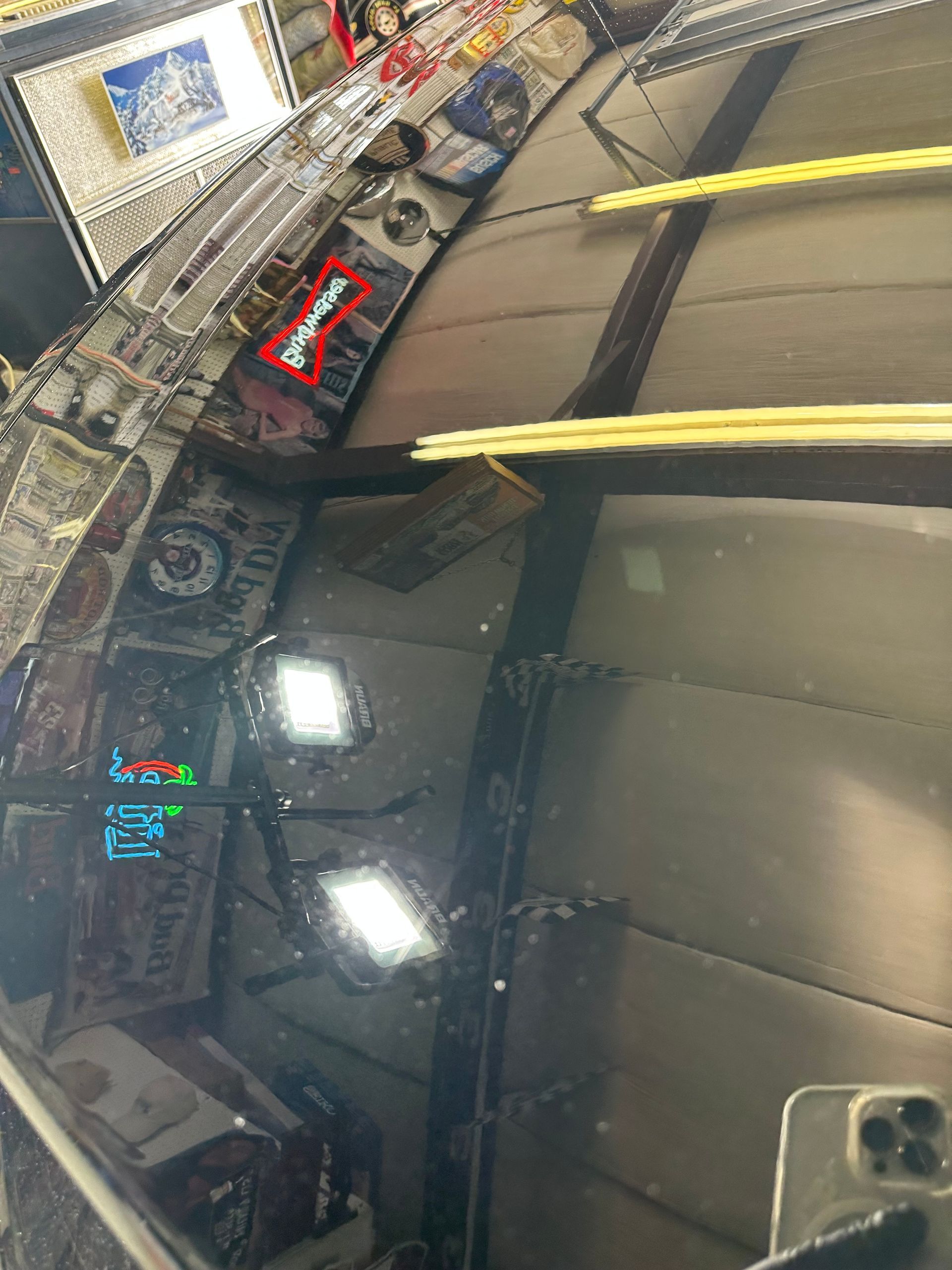 A phone is sitting on a table in front of a mirror.