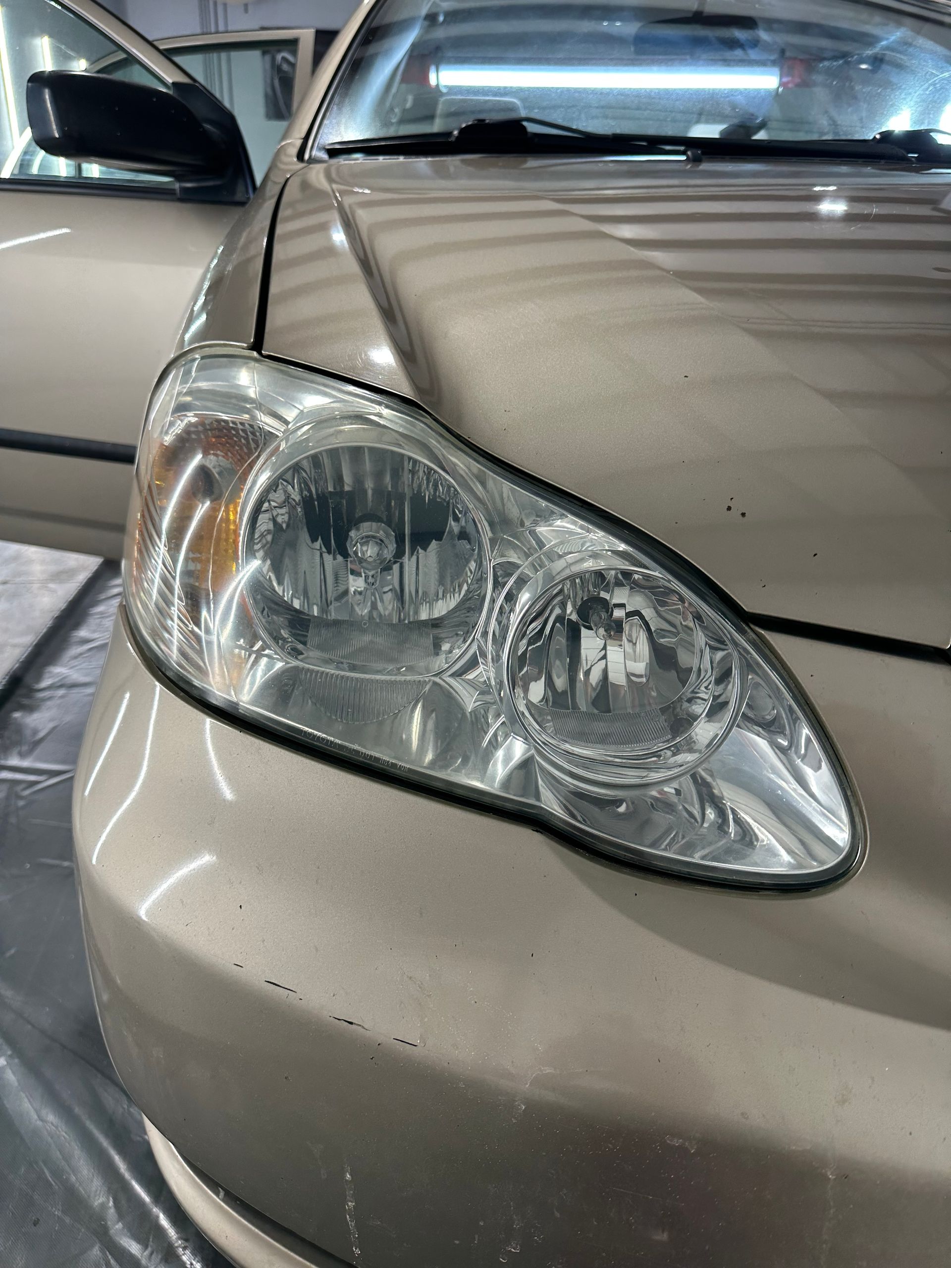 A close up of a car 's headlight in a garage.