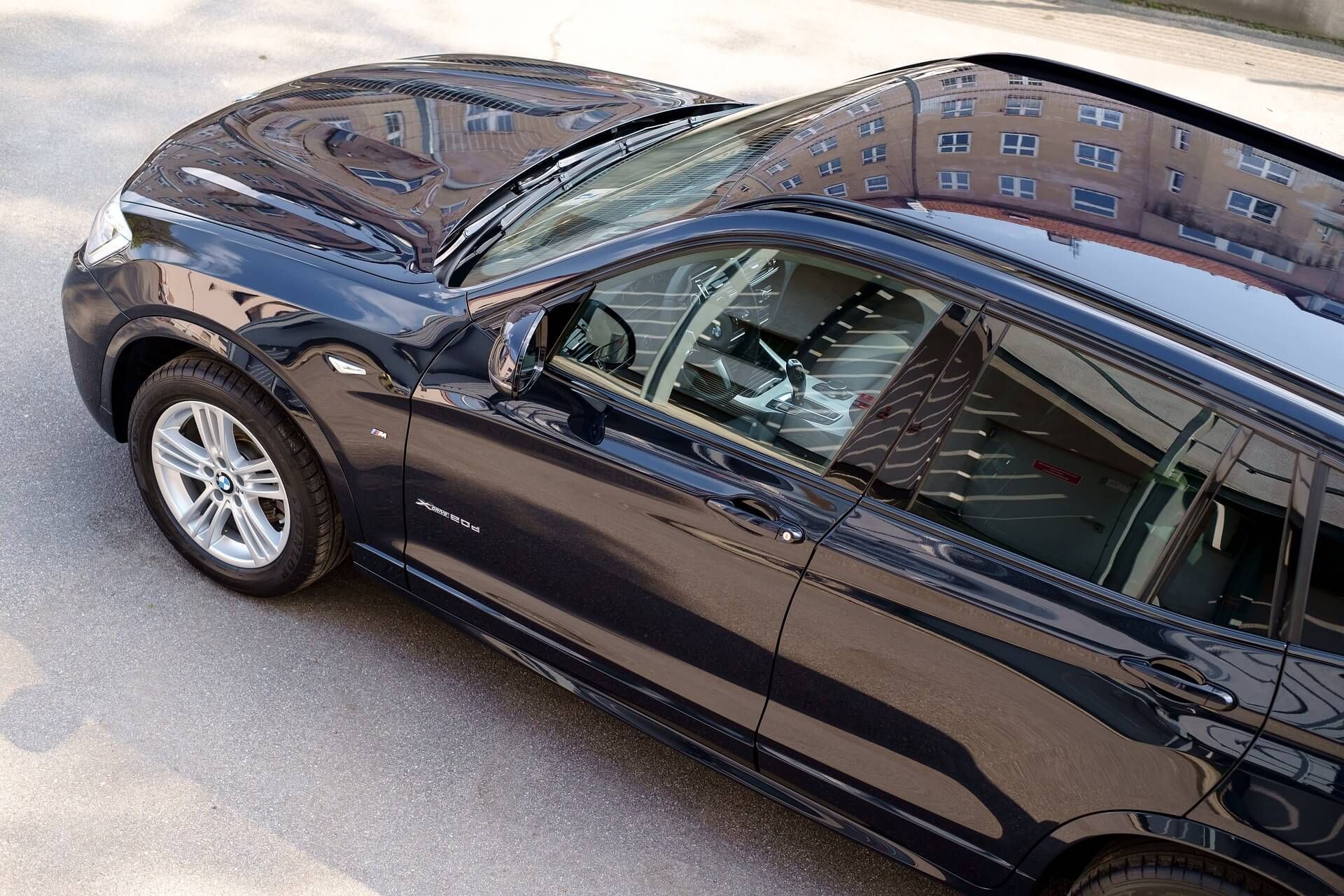 A black car is parked on the side of the road.