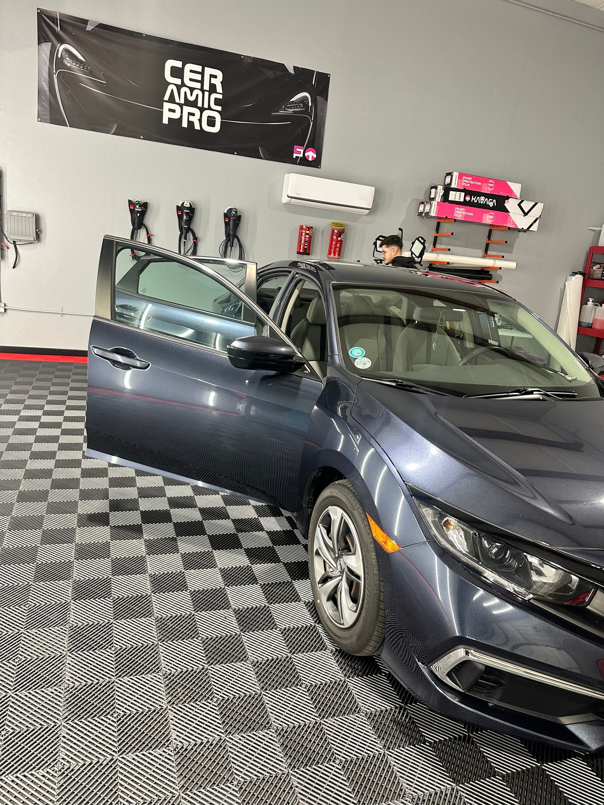 A car is parked in a garage with its doors open.