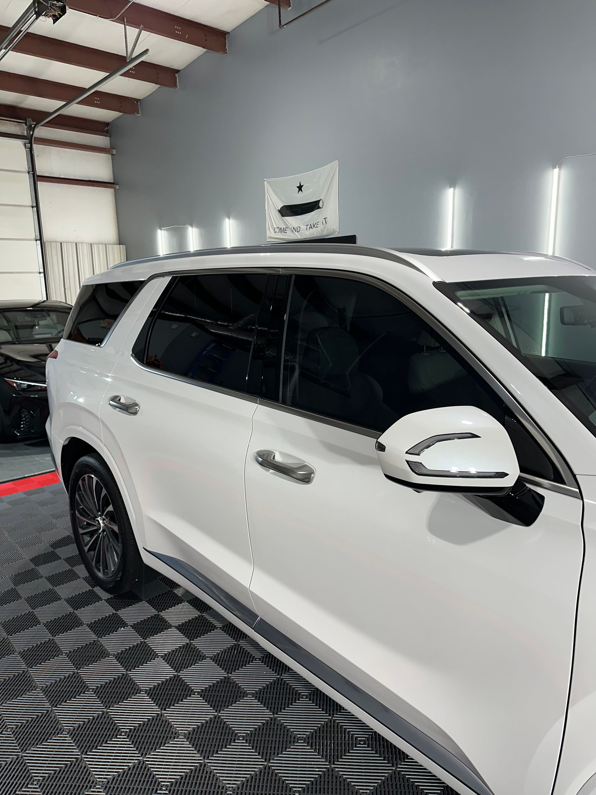 A white suv is parked in a garage with a sign on the roof.