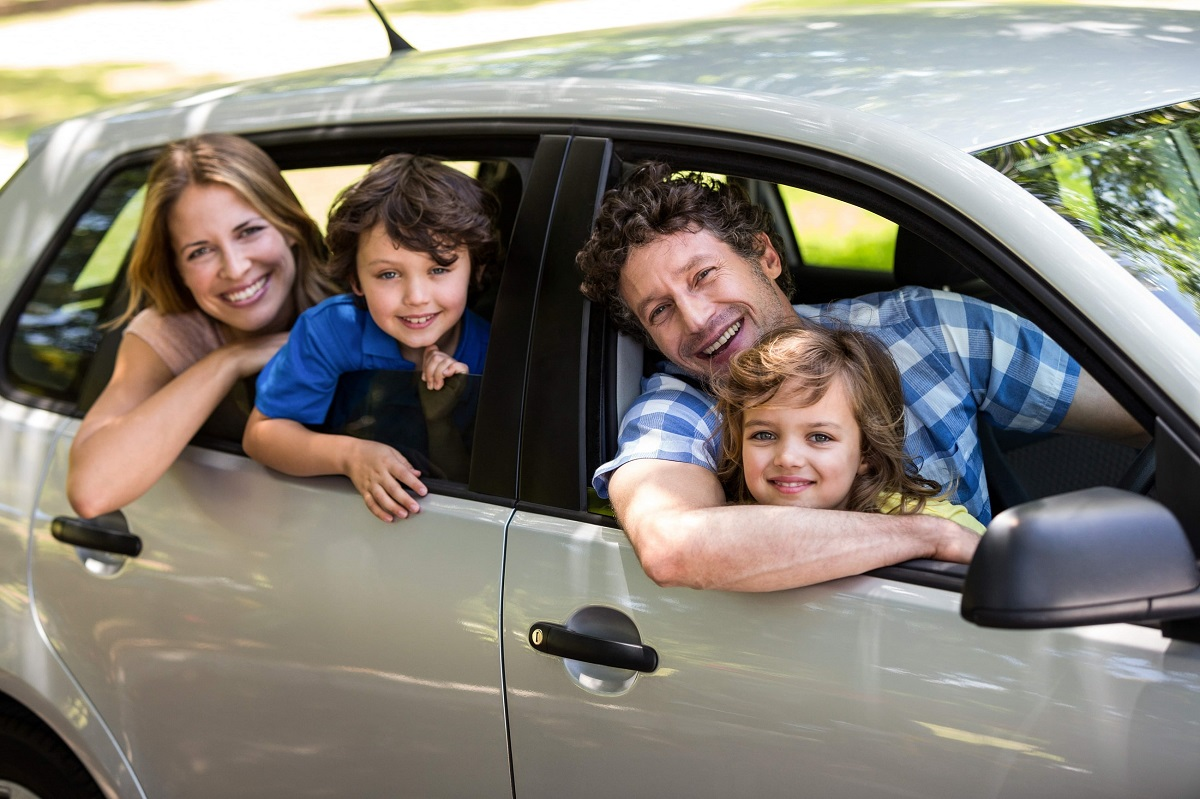 A cheerful family collecting an affordable rental car in Brisbane city, ready for travel