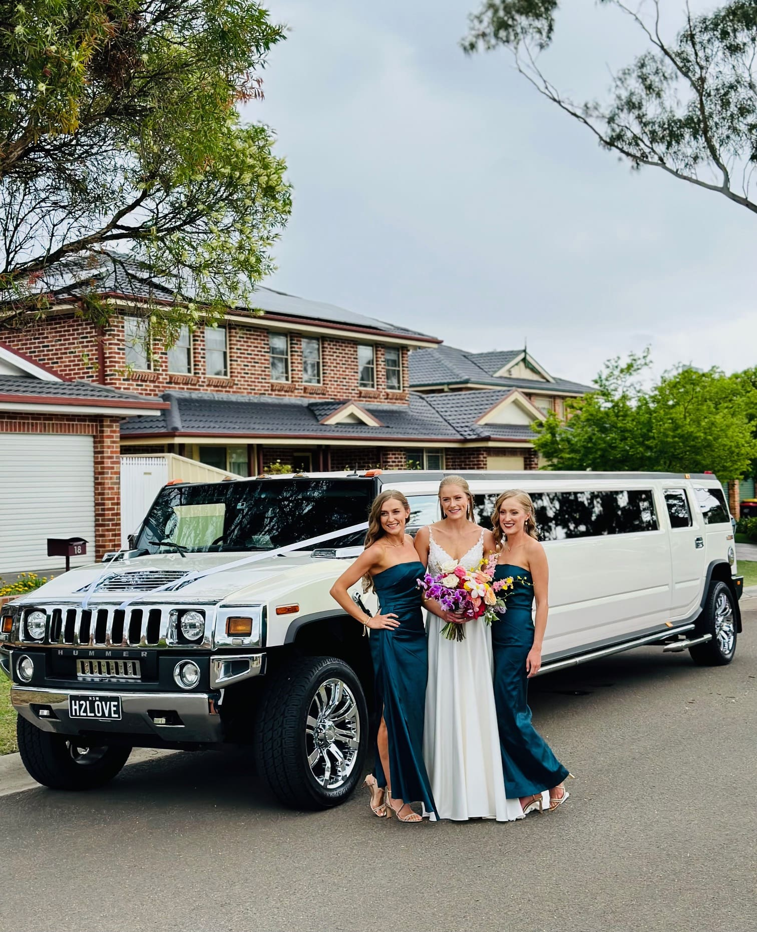 A chauffeur opening the door of a stretch limousine for VIP clients at an event in Sydney
