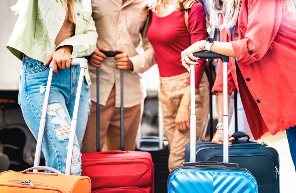 A group of people are standing next to each other with luggage.