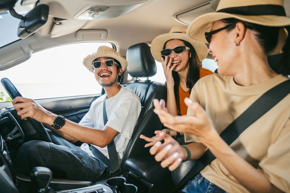 A group of people are sitting in a car wearing hats and sunglasses.