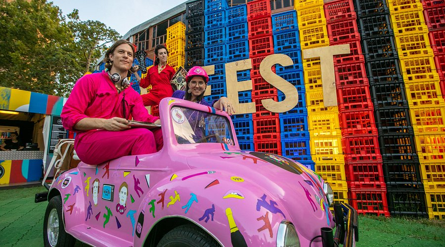 A group of people are sitting in a pink car.
