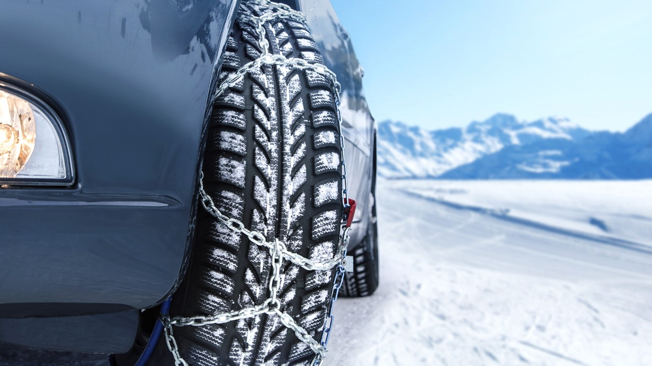 Close-up of snow chains on car tires ready for snowy mountain roads