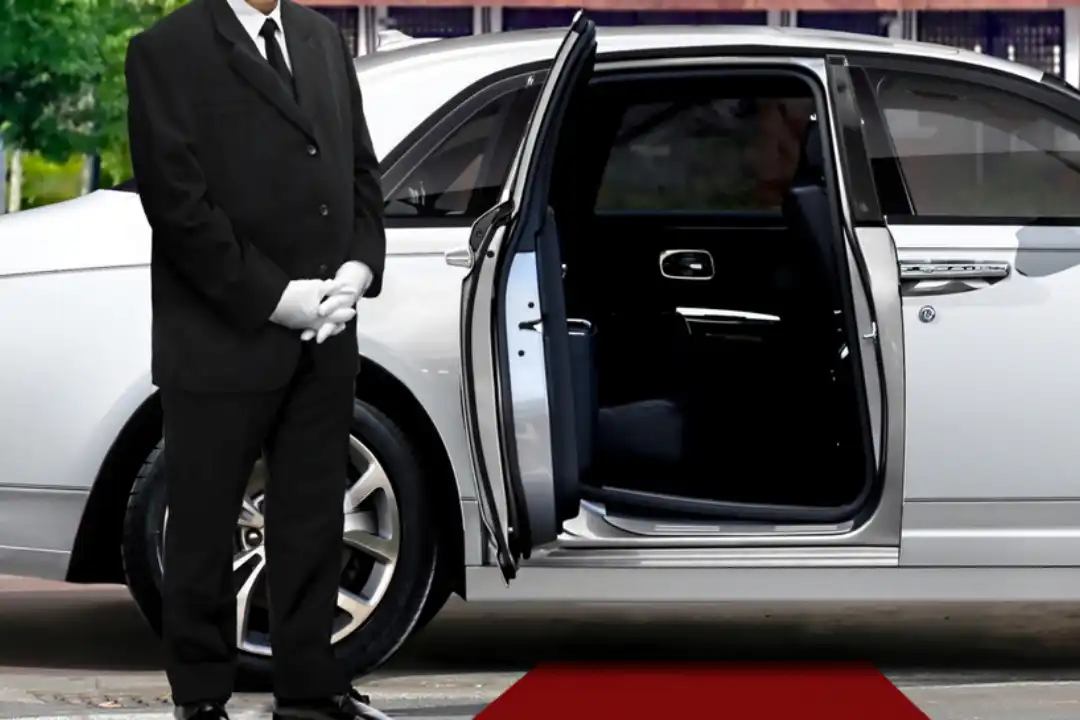 A man in a suit and tie is standing next to a white car