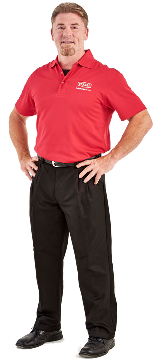 A man in a red shirt and black pants is standing with his hands on his hips.