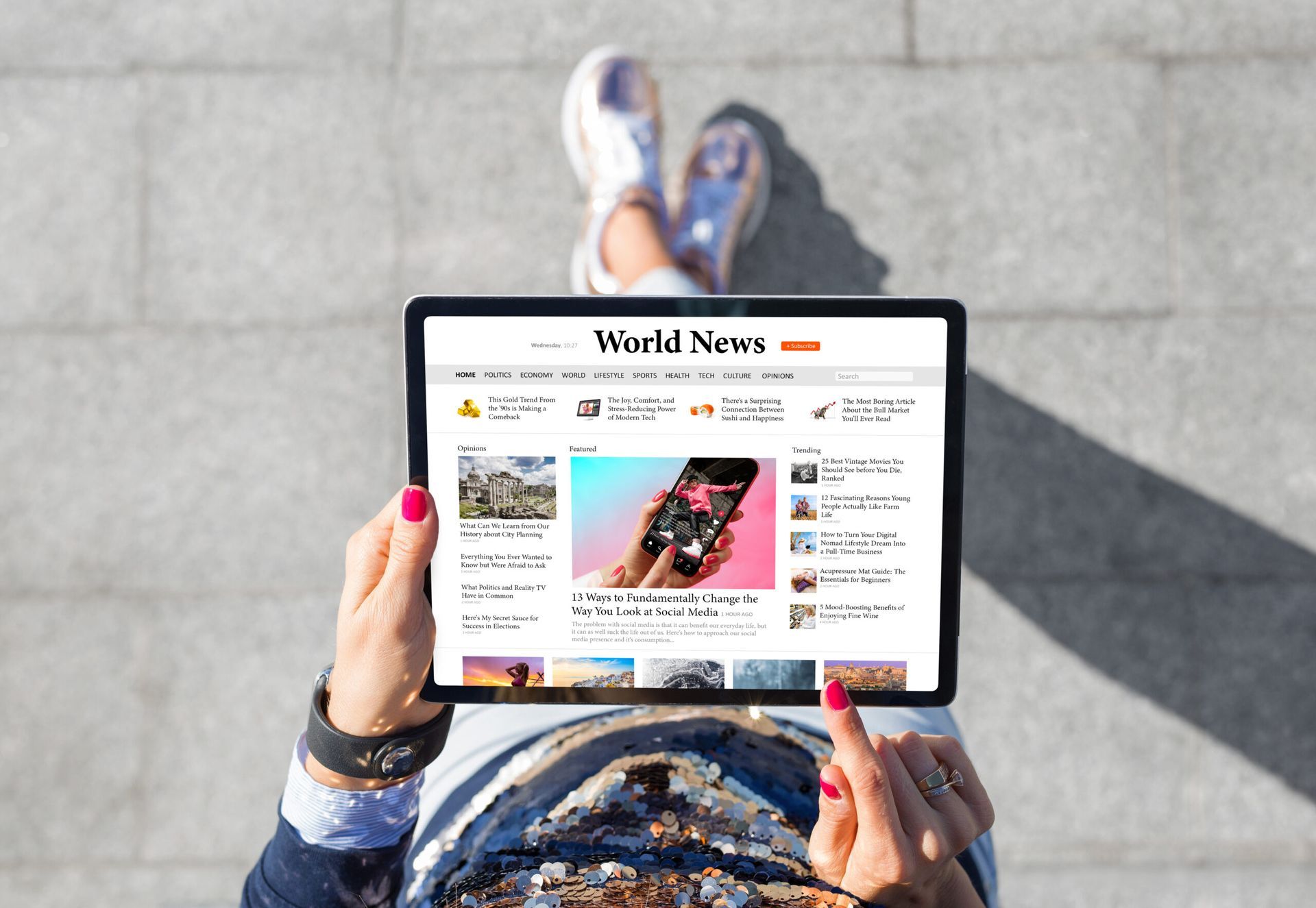 A woman is holding a tablet with a world news website on it.