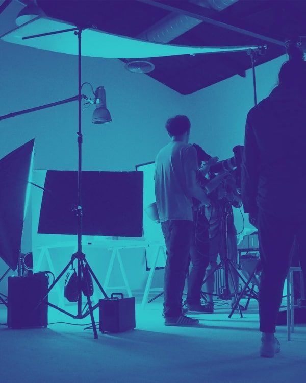 A group of people are standing in a room with a lot of equipment.